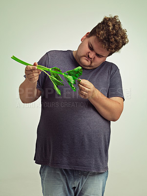 Buy stock photo Plus size, diet and unhappy man with vegetable for health benefits, nutrition and wellness in studio in white background. Weight loss, celery and male person for healthy food, wellbeing and detox