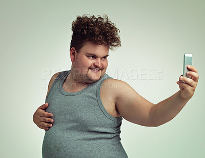 Buy stock photo Shot of an overweight man taking a selfie with his phone