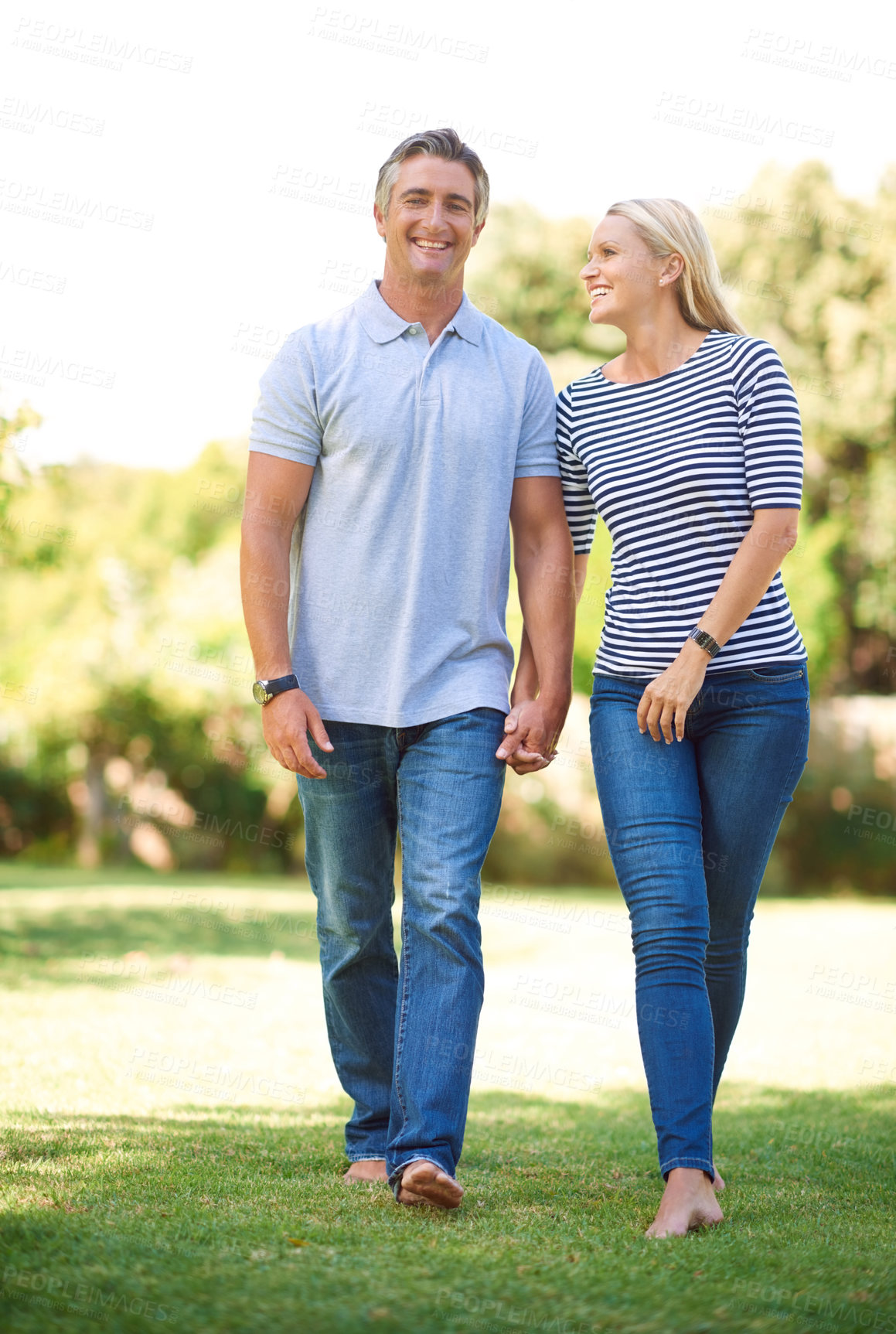 Buy stock photo Full length portrait of mature couple walking hand-in-hand in the park