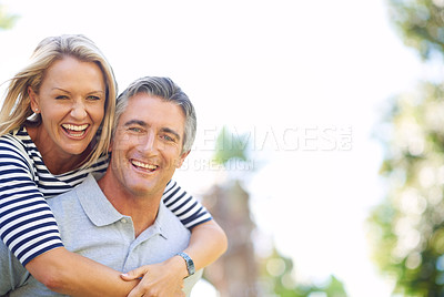 Buy stock photo Cropped portrait of a handsome mature man piggybacking his wife in the park