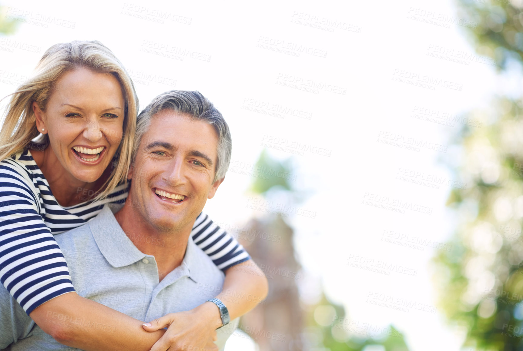 Buy stock photo Cropped portrait of a handsome mature man piggybacking his wife in the park