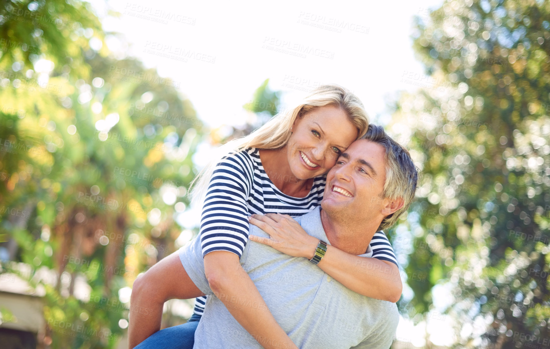 Buy stock photo Hug, piggyback and smile with couple in park together for anniversary, bonding or romance. Adventure, love for vitamin D with mature man and woman outdoor in nature for summer holiday or vacation