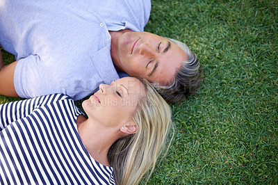 Buy stock photo High angle shot of a mature couple lying in the park
