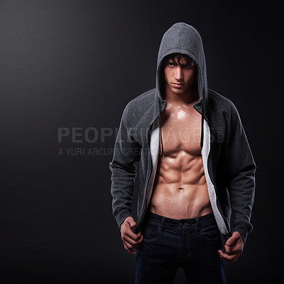 Buy stock photo Studio shot of a handsome bare-chested young athlete standing against a black background