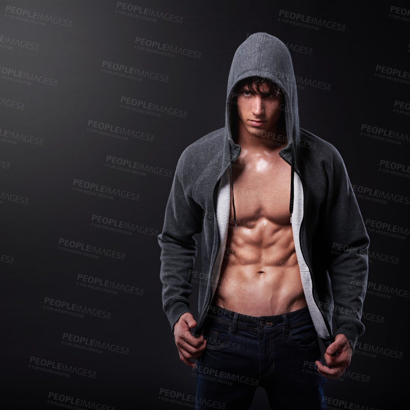 Buy stock photo Studio shot of a handsome bare-chested young athlete standing against a black background