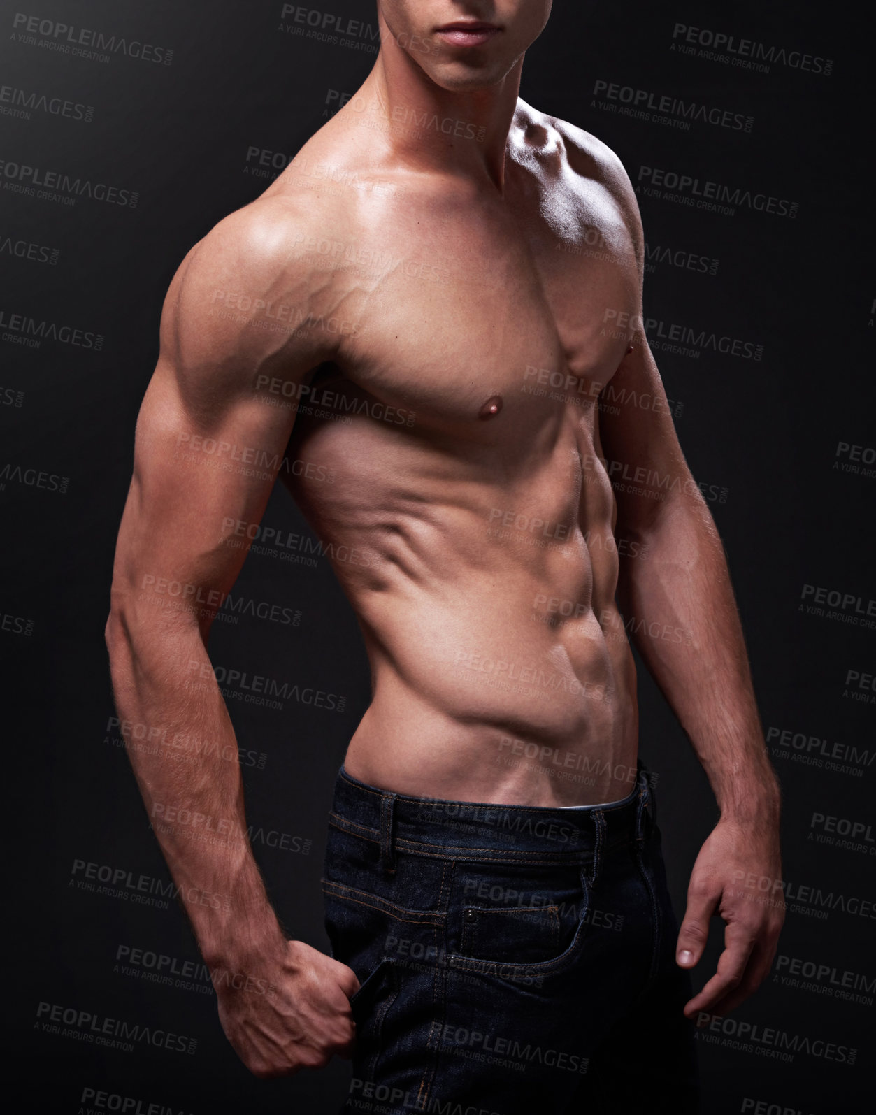 Buy stock photo Studio shot of a handsome bare-chested young athlete standing against a black background