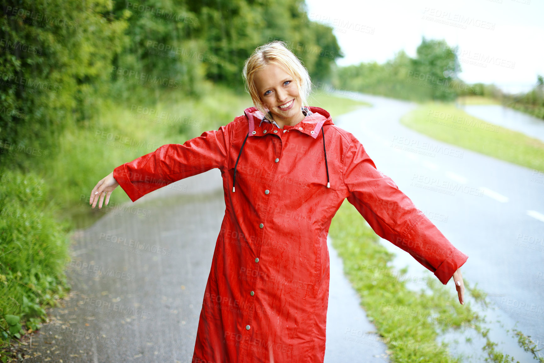 Buy stock photo Woman, smile and raincoat in rain with arms, wet and cold from weather, winter and nature. Happy female person, fashion and red jacket in storm, rainfall and protection from water, face and outdoors