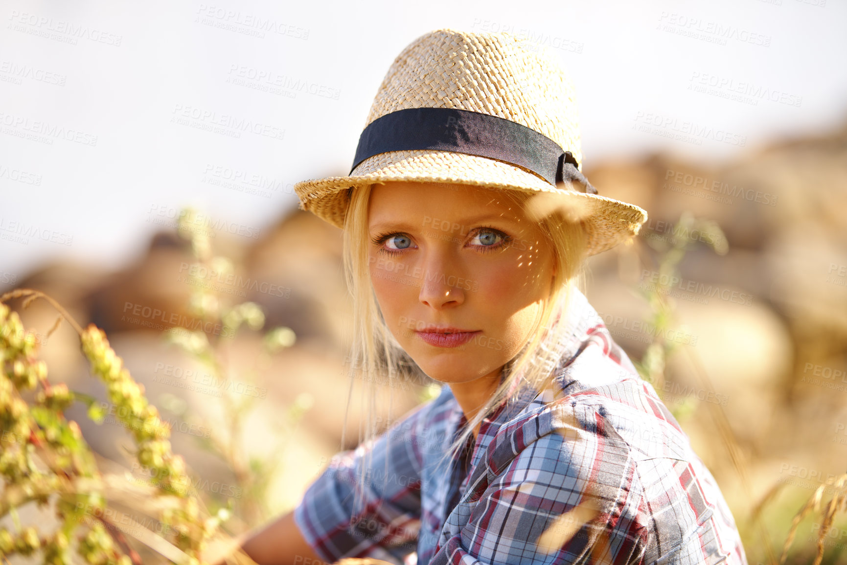 Buy stock photo Serious, portrait and young woman in nature with straw hat sitting in outdoor garden for fresh air. Beautiful, fashion and female person from Australia in the forest, woods or field with casual style