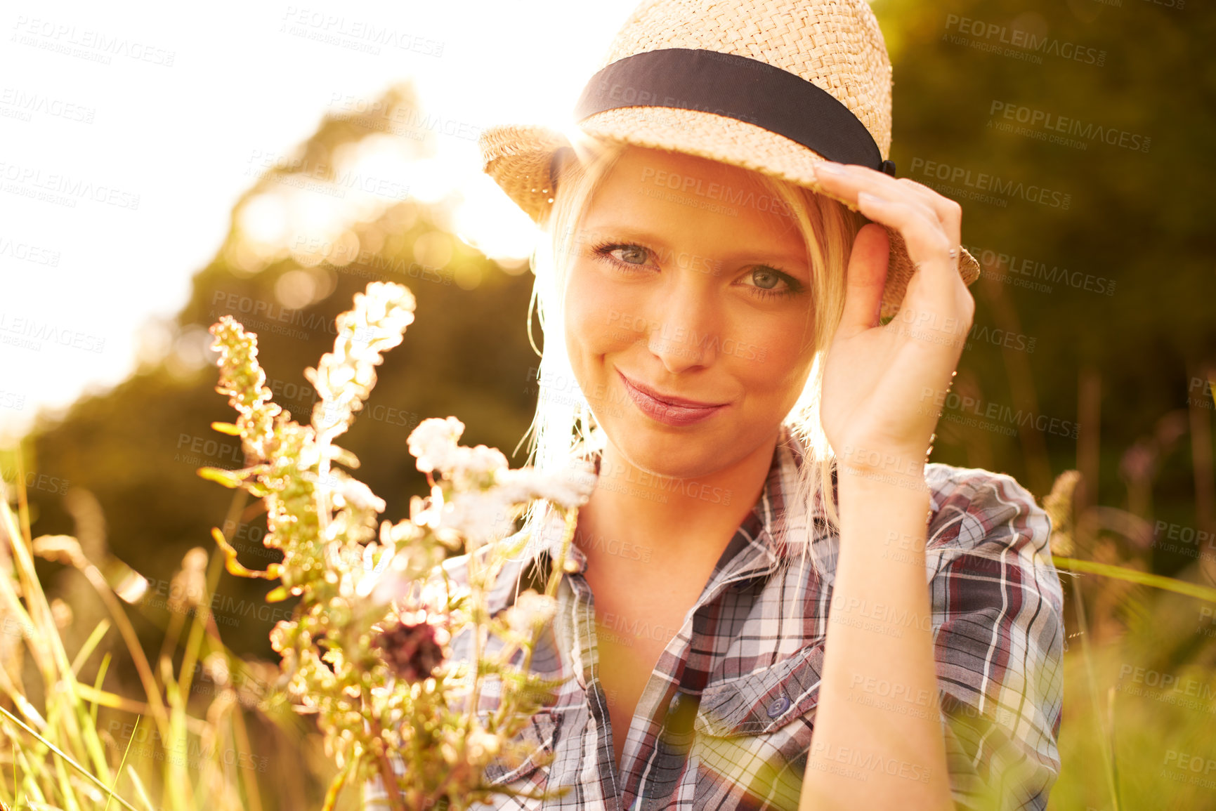 Buy stock photo Lens flare, countryside and portrait of woman with flower in field for freedom, wellness and relax outdoors. Nature, summer and hipster female person smile in meadow for sustainability and ecology