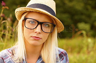 Buy stock photo Glasses, portrait and young woman in nature with a straw hat sitting in outdoor garden for fresh air. Serious, fashion and female person from Australia in the forest, woods or field with casual style