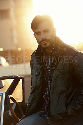 Buy stock photo Shot of a young man sitting on his car