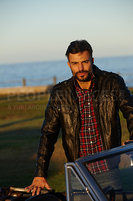 Buy stock photo Portrait, confident or man by car at sea for solo holiday, outdoor travel and vacation for road trip. Spain, fashion and cool driver by vehicle at sunrise for adventure, journey and weekend break