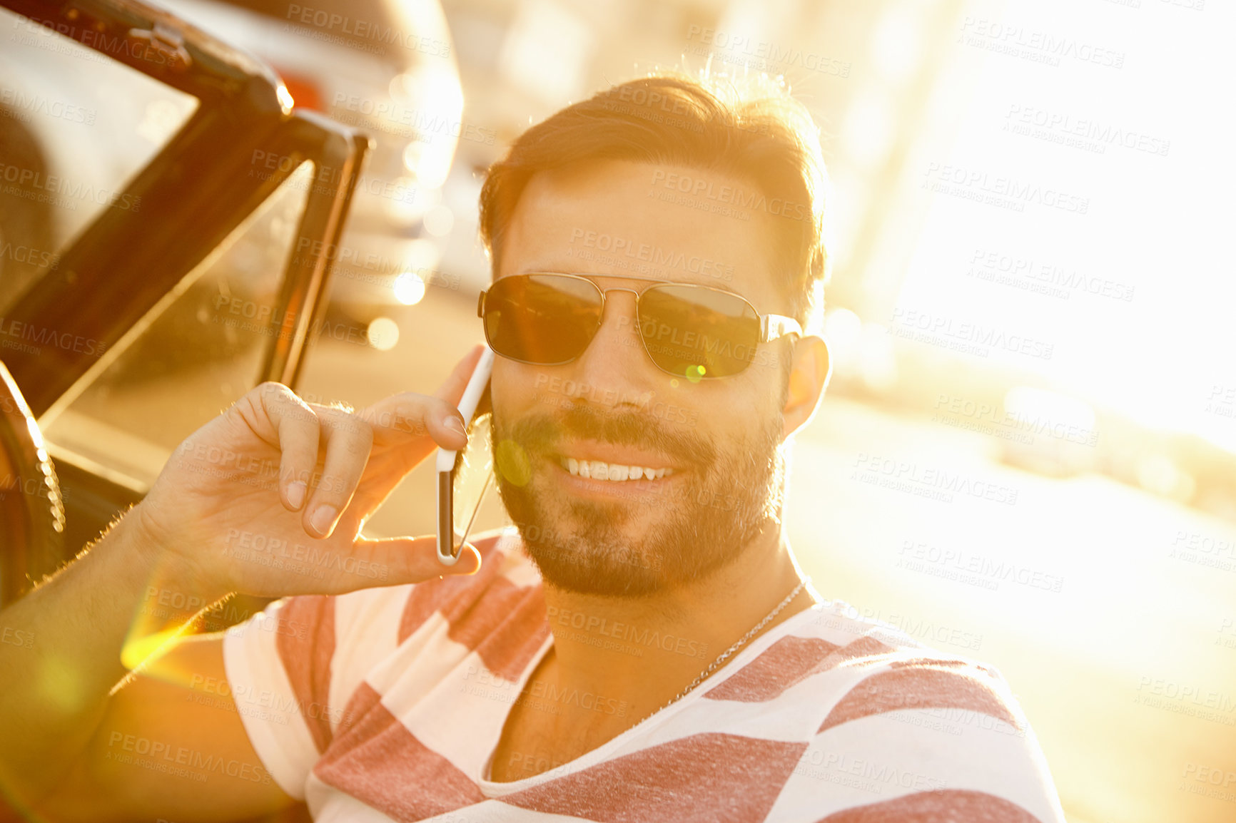 Buy stock photo Shot of a young man sitting in his car while talking on his cellphone