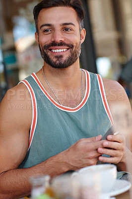 Buy stock photo A young man sitting in a coffee shop while texting