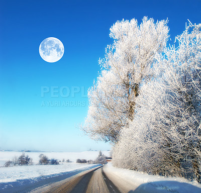 Buy stock photo The moon in winter landscape. Road with ice on a winter landscape during noon. The Moon shines through clear clouds