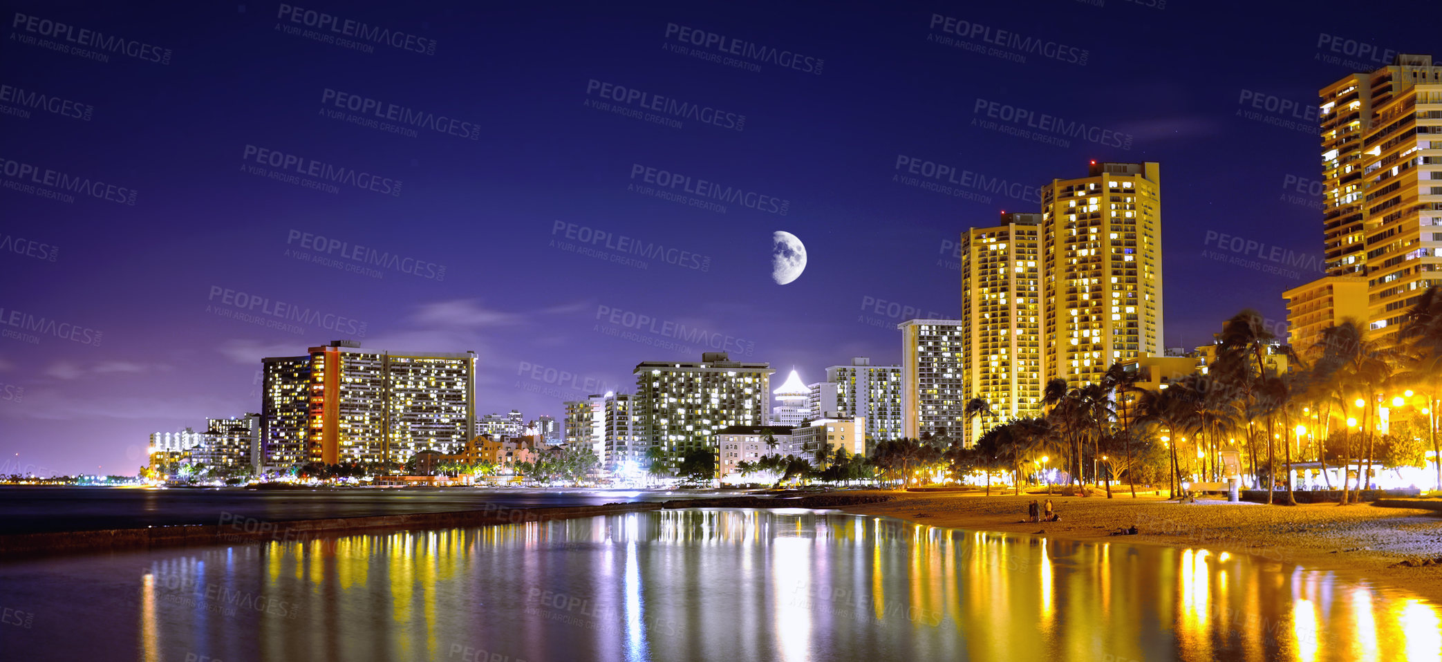 Buy stock photo Night, city and coastal with lights, moon and journey with vacation, holiday and getaway trip. Waikiki, urban town and buildings with reflections, water and seaside with adventure or destination spot