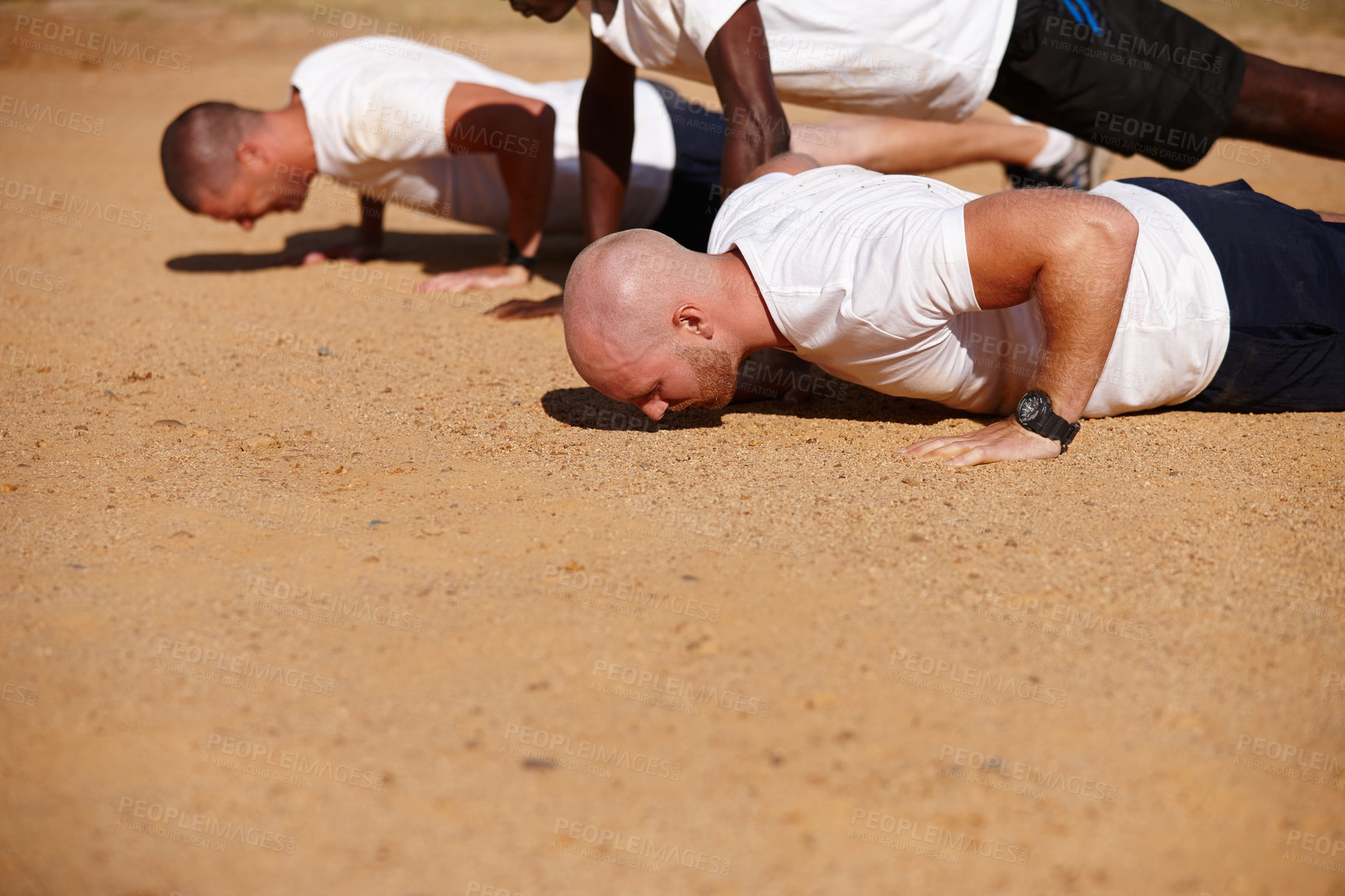 Buy stock photo Shot of a group of men doing push-ups at a military bootcamp