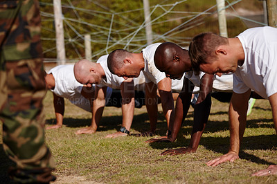 Buy stock photo Shot of a group of men doing push-ups at a military bootcamp