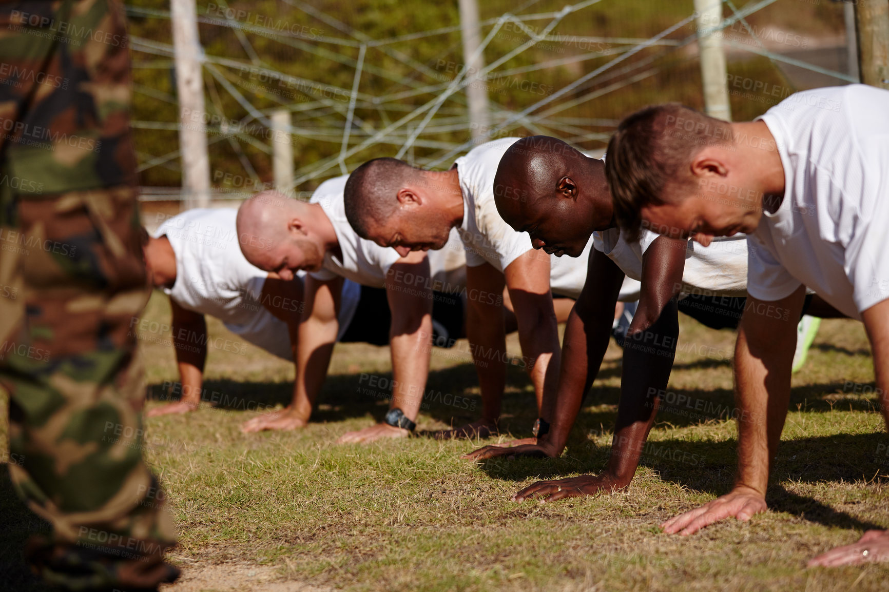 Buy stock photo Shot of a group of men doing push-ups at a military bootcamp