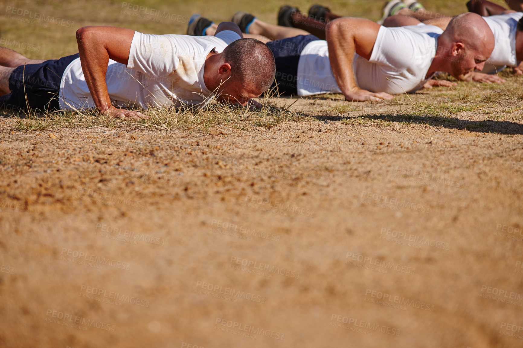 Buy stock photo Shot of a group of men doing push-ups at a military bootcamp