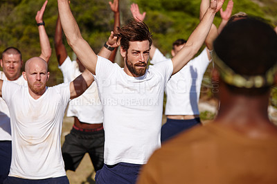 Buy stock photo Shot of a group of men doing star jumps at a military bootcamp