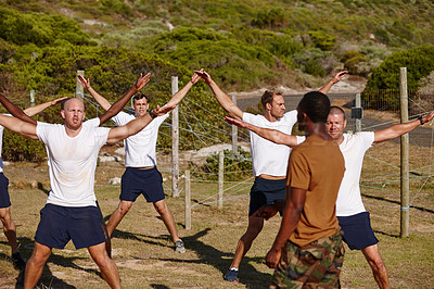 Buy stock photo Shot of a group of men doing star jumps at a military bootcamp