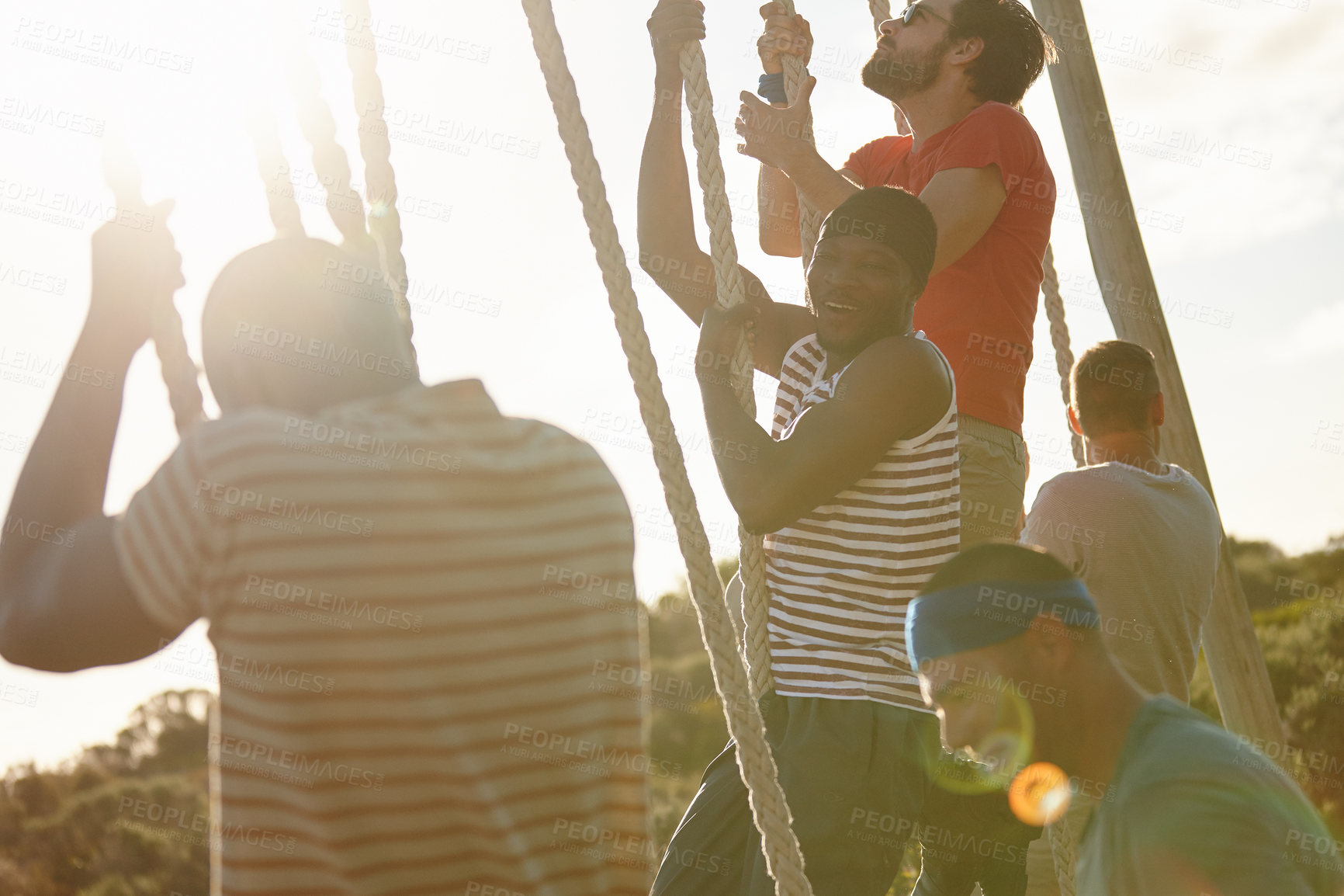 Buy stock photo Shot of a group of men climbing up ropes at a military bootcamp