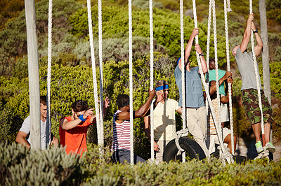 Buy stock photo Shot of a group of men climbing up ropes at a military bootcamp