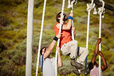 Buy stock photo Shot of a group of men climbing up ropes at a military bootcamp