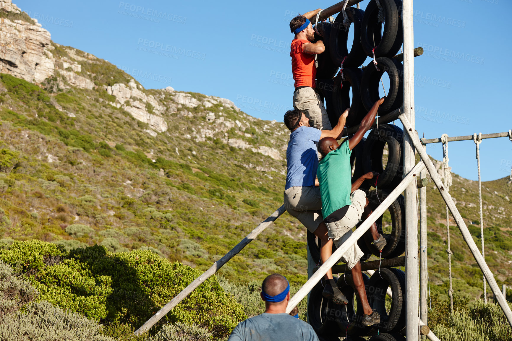 Buy stock photo Shot of a group of men climbing over an obstacle at a military bootcamp