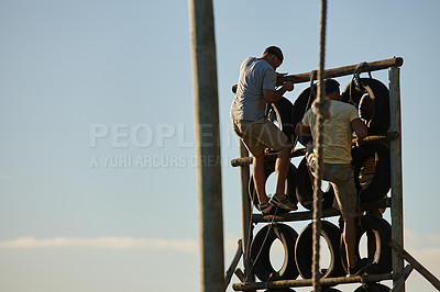 Buy stock photo Shot of men climbing over an obstacle at bootcamp