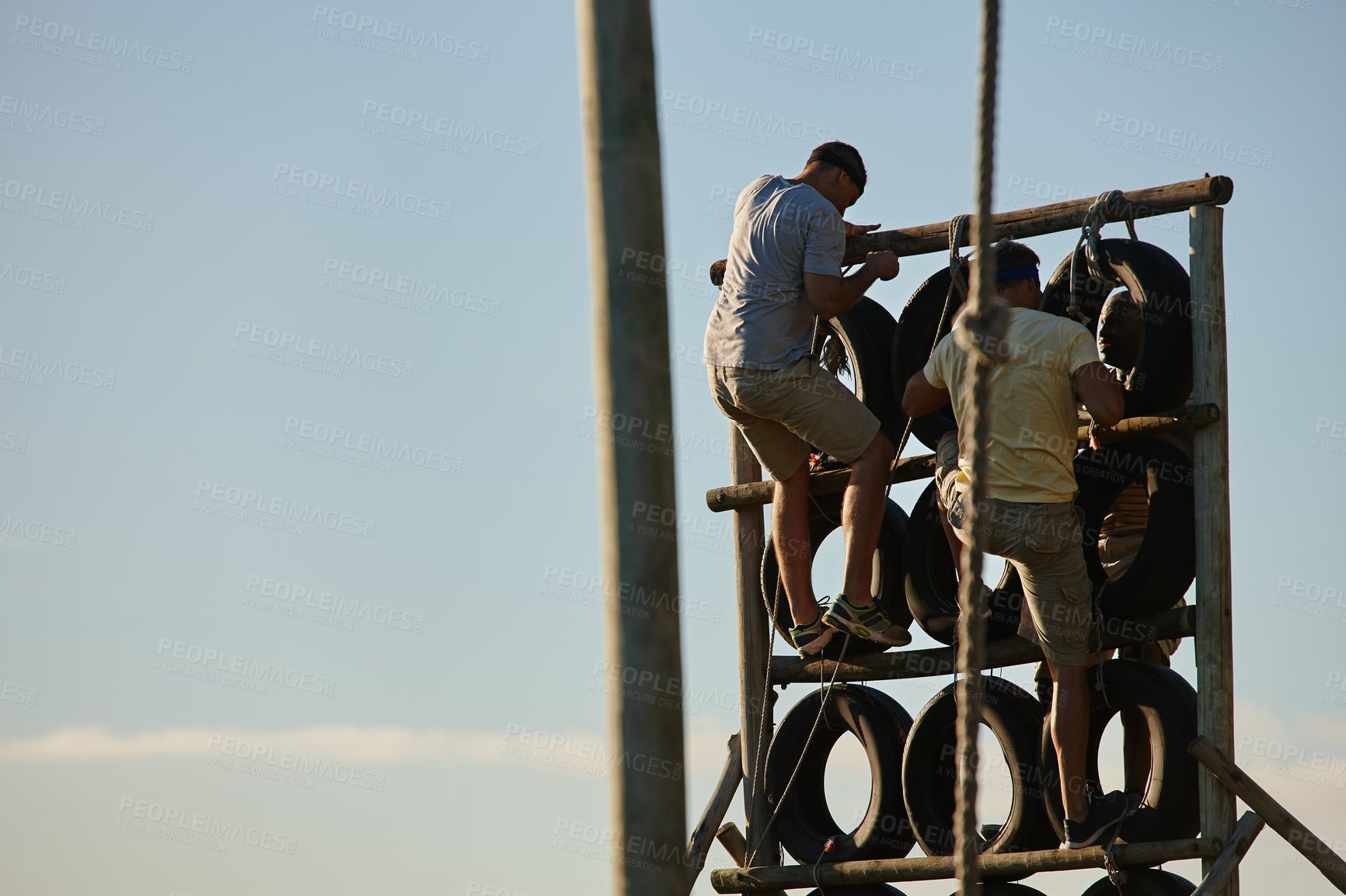 Buy stock photo Shot of men climbing over an obstacle at bootcamp