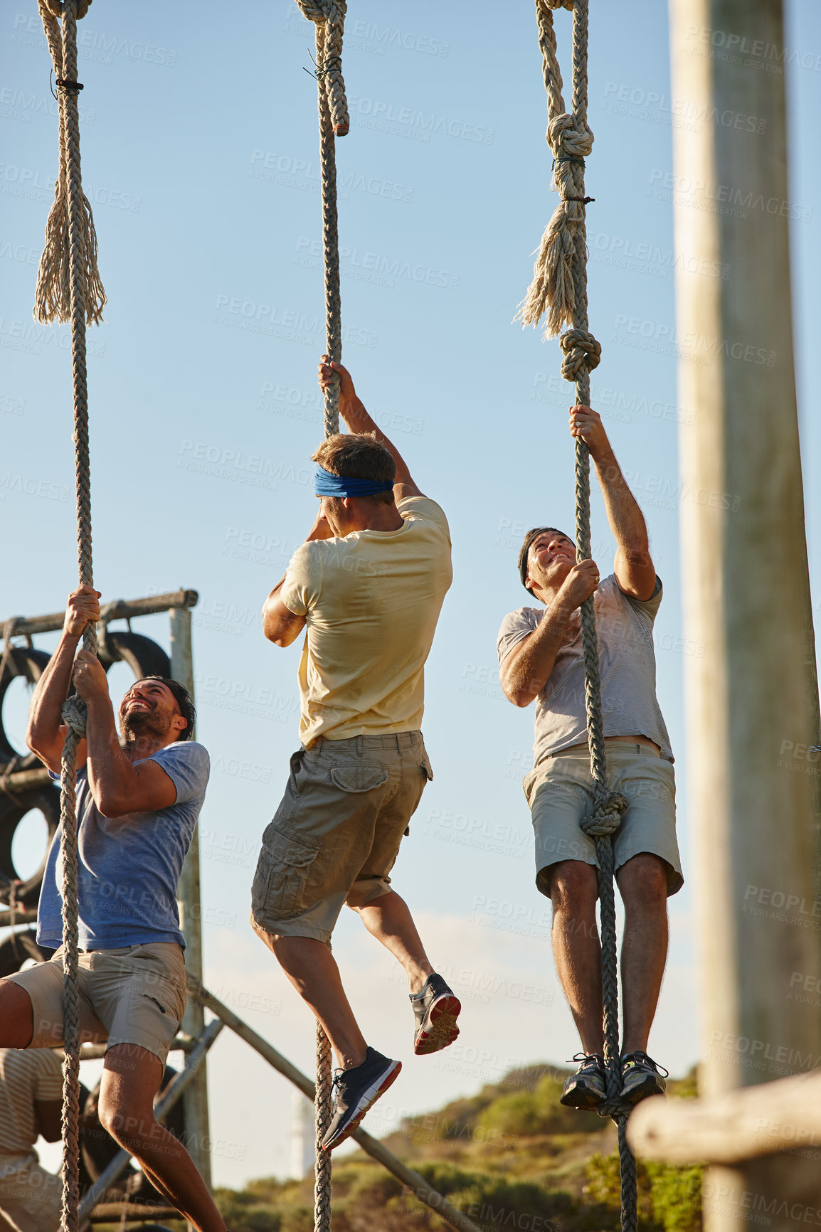 Buy stock photo Shot of a group of men going through an obstacle course at a military bootcamp