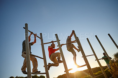 Buy stock photo Climbing, effort and obstacle course with military men outdoor on blue sky for challenge or training. Army, drill and exercise with group of people at base for fitness, team building or workout