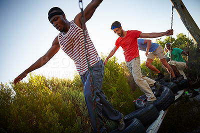 Buy stock photo Shot of a group of men going through an obstacle course at bootcamp