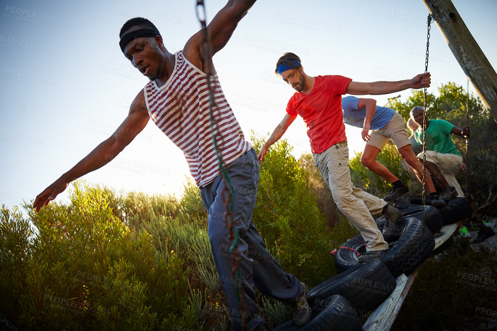 Buy stock photo Shot of a group of men going through an obstacle course at bootcamp