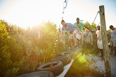 Buy stock photo Shot of a group of men going through an obstacle course at bootcamp