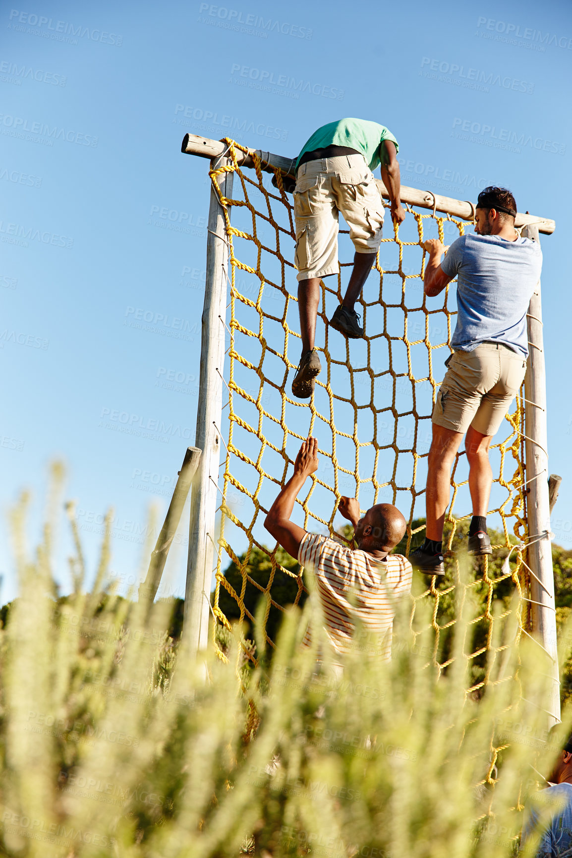 Buy stock photo Shot of a group of men going through an obstacle course at military bootcamp