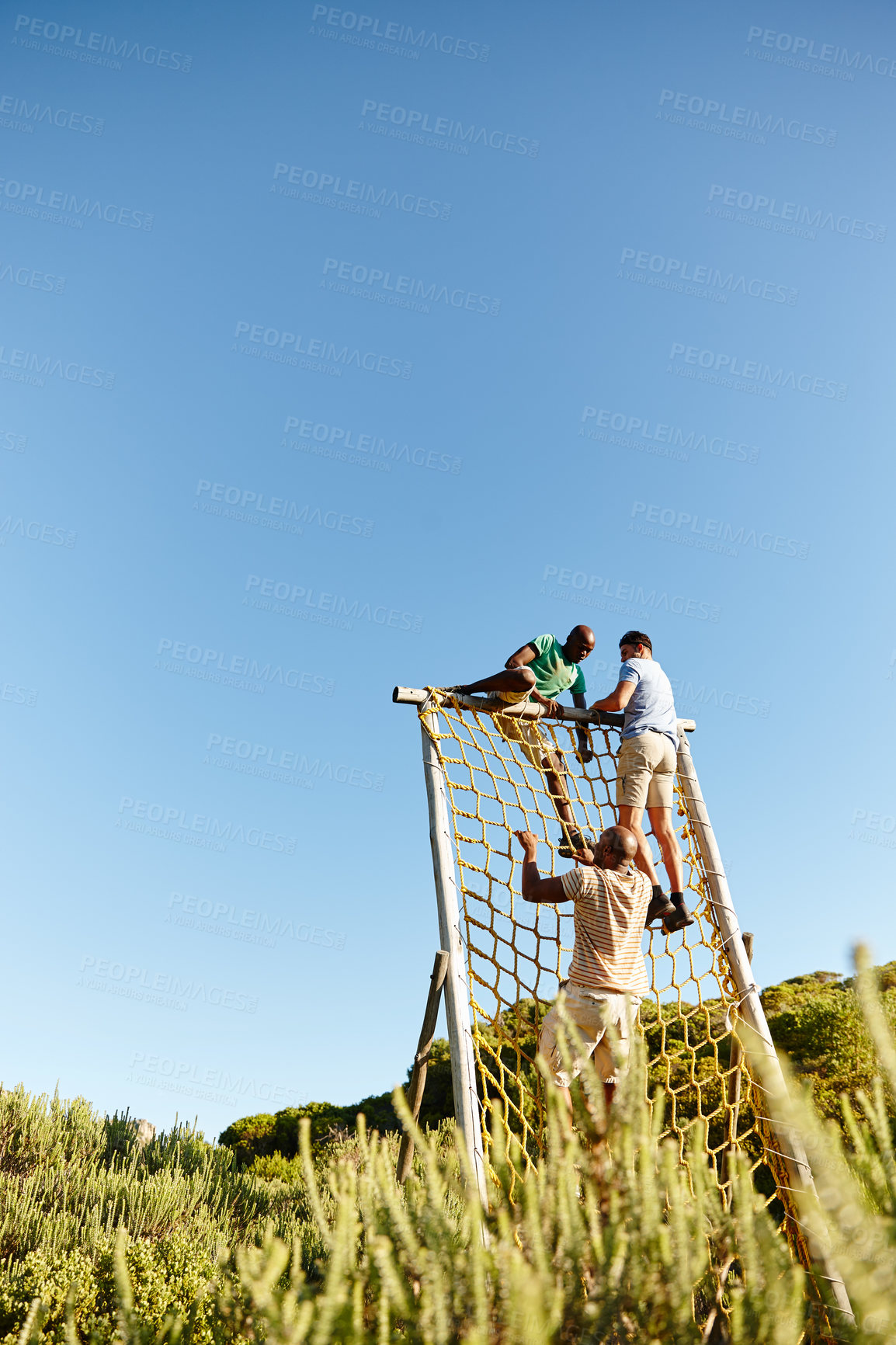 Buy stock photo Shot of a group of men going through an obstacle course at military bootcamp