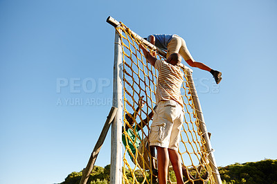 Buy stock photo Shot of a group of men going through an obstacle course at military bootcamp