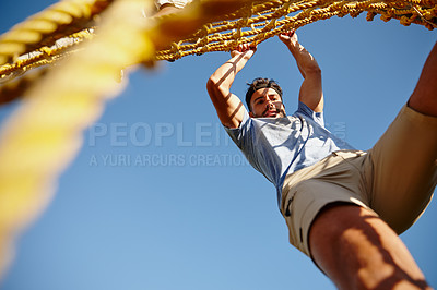 Buy stock photo Shot of a young man gripping a rope wall at bootcamp