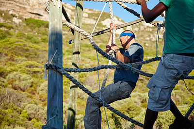 Buy stock photo Shot of two men going through an obstacle course at bootcamp