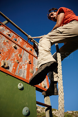 Buy stock photo Obstacles, fitness or man climbing wall for strength, endurance exercise or bootcamp challenge. Rope, below or barrier in physical test for outdoor workout, military drill and training assessment