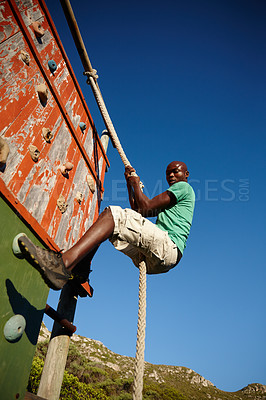 Buy stock photo Shot of a young man climbing over an obstacle at military bootcamp