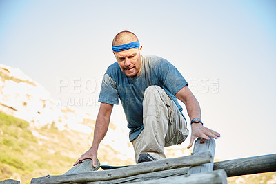 Buy stock photo Shot of a man going over an obstacle at bootcamp