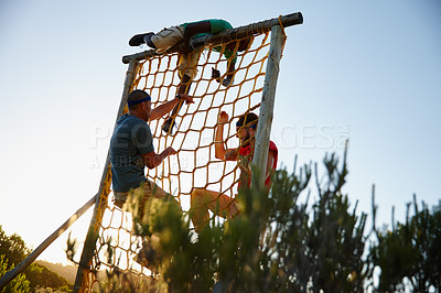Buy stock photo Shot of a group of men going through an obstacle course at bootcamp