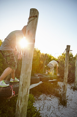 Buy stock photo Shot of men going across an obstacle at bootcamp