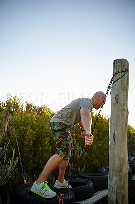 Buy stock photo Shot of a man going across an obstacle at bootcamp