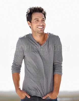 Buy stock photo A handsome young man standing outside with his hands in his pockets