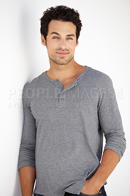 Buy stock photo Portrait of a handsome young man standing against a white wall